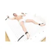 nexus-bed-restraint-kit - Las Lingerie Man lying on a bed in white boxers, wrists and ankles strapped to the bed.